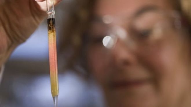 Janet Hope sostiene un tubo con el pigmento hallado en rocas de 1.100 millones de años