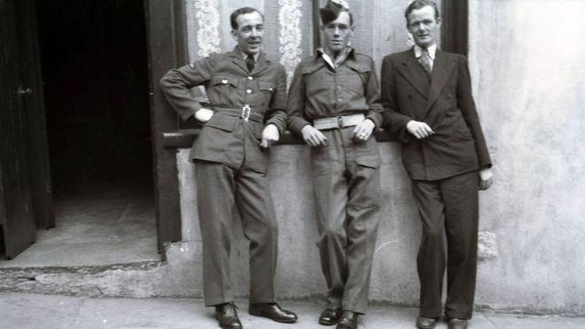 Он слева в группе из трех человек, изображенных возле своего дома в Эннискиллене после войны в 1946 году