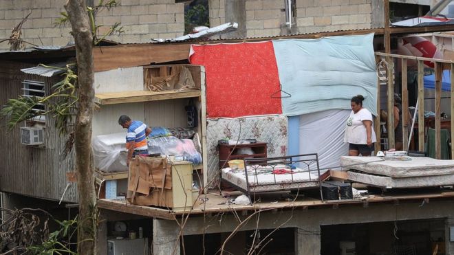 Жители спасают, что они могут из своего дома, который был разрушен, когда ураган Мария в Коросале, Пуэрто-Рико