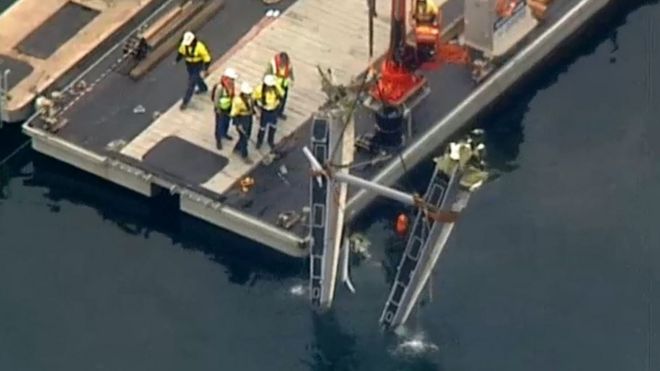 Authorities use a crane to recover part of the seaplane on Thursday