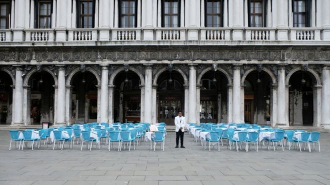 konobar između praznih stolova u restoranu na trgu svetog marka u veneciji, 5. mart