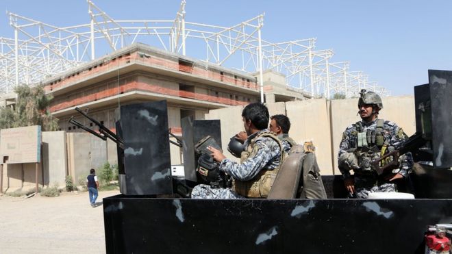 Иракские силы безопасности охраняют вход на строящийся спортивный стадион в районе Садр Сити в Багдаде (2 сентября 2015 года)