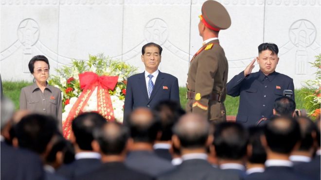 Лидер Северной Кореи Ким Чен Ын (R) приветствует, как почетный караул проходит мимо него и его тети Ким Чен Хи (слева) в Пхеньяне 25 июля 2013 года,