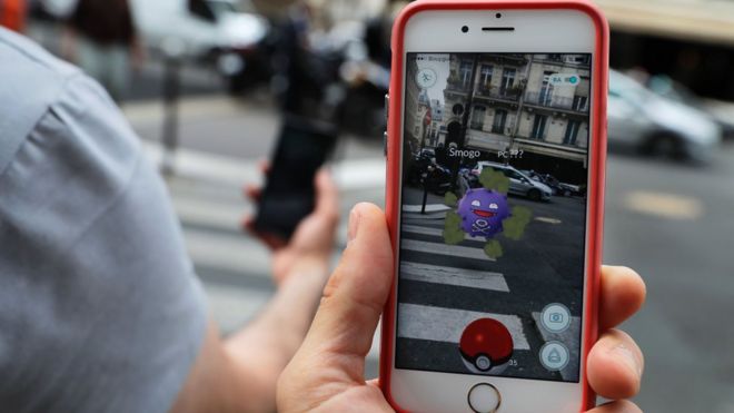 На этом снимке, сделанном 26 июля 2016 года возле пирамиды Лувра в Париже, изображен «Pokemon Go». приложение на экране смартфона