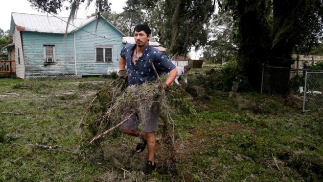 José Lobato (izquierda) y su hermano Tony Lovato recogen ramas y escombros dejados por Irma en su casa de Bowling Green, Florida, Estados Unidos, el 11 de septiembre.