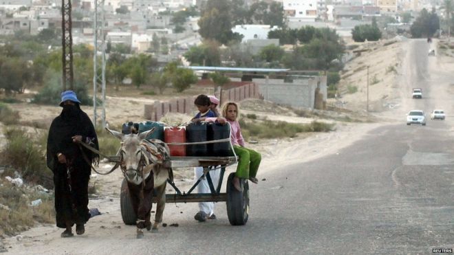 Семья использует осла для перевозки воды по дороге в Шейх-Цувейд, Египет (24 мая 2015 г.)
