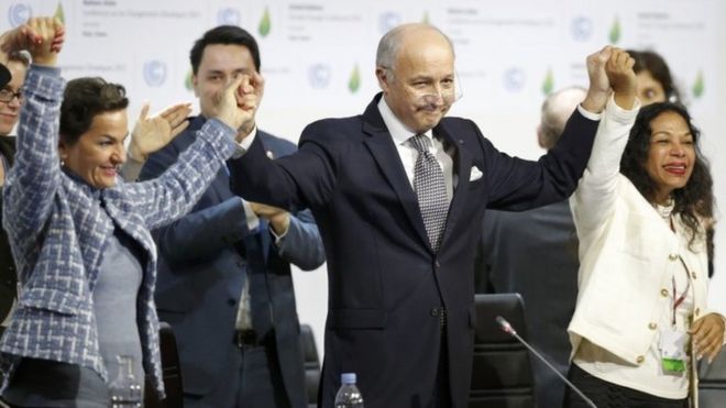 French Foreign Minister Laurent Fabius (centre) and other delegates react to the climate deal in Paris