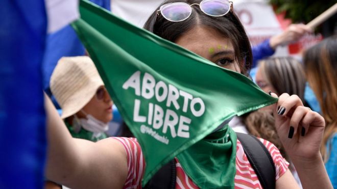Mujer manifestante con pañuelo verde que dice "aborto libre".