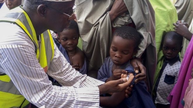 Нигерийский доктор Рилвану Мохаммед (слева) Исполнительный секретарь Федерального столичного совета по развитию первичной медико-санитарной помощи делает прививку от менингита