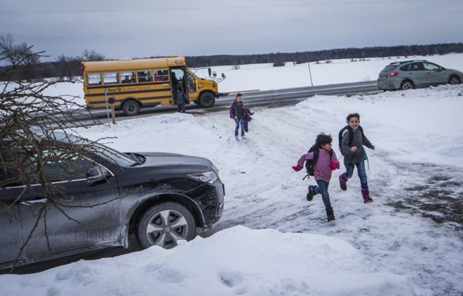 Дети сирийских беженцев из семьи Аль-Джасем возвращаются домой после того, как их отвезли в школьном автобусе к их временному дому в Пиктоне, Онтарио, Канада, среда, 20 января 2016 г.