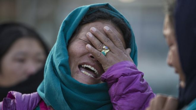 Родственники реагируют как вертолет, несущий трупы альпинистов на вертолетной площадке Учебного госпиталя в Катманду