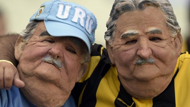 Dos personas con la máscara de Mujica.