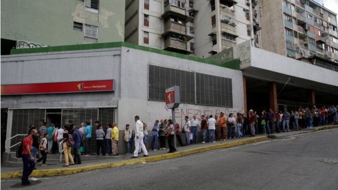 Люди выстраиваются в очередь, чтобы попасть в отделение Banco de Venezuela в Каракасе, Венесуэла 13 декабря 2016 года
