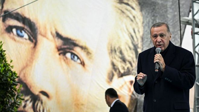 Реджеп Тайип Эрдоган на фоне плаката с Мустафой Ататюрком