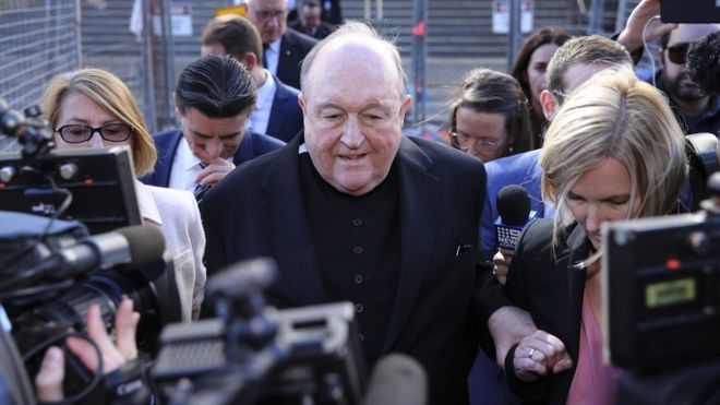 El arzobispo Philip Wilson abandona el tribunal rodeado de periodistas