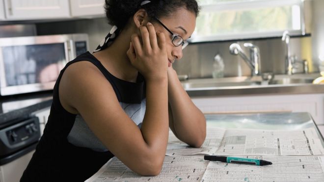 Una mujer mirando anuncios en el periódico