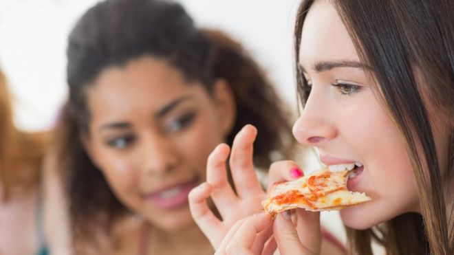 Una mujer comiendo pizza
