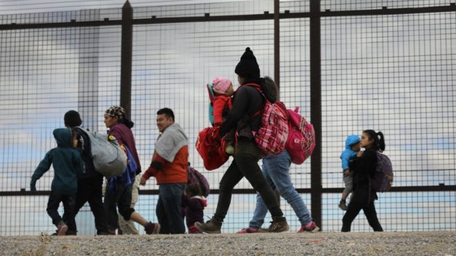 Иммигранты из Центральной Америки идут вдоль пограничной ограды после пересечения Рио-Гранде из Мексики 1 февраля 2019 года в Эль-Пасо, штат Техас