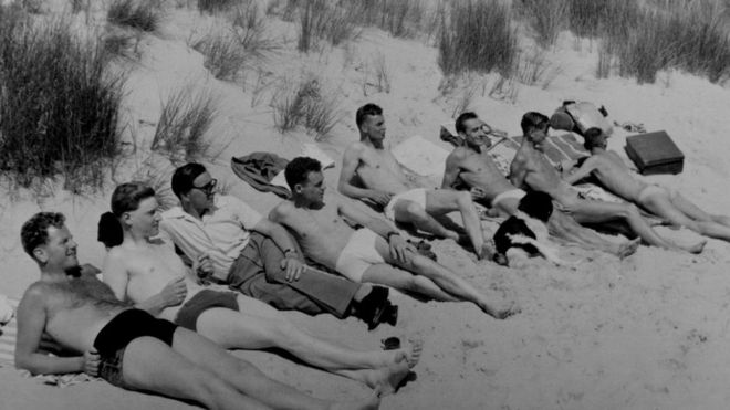 Впитывание лучей на пляже Борнмута в 1950-е годы: группа друзей Джорджа наслаждается солнцем