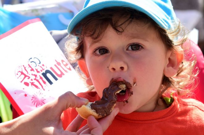 Ребенок ест тарелку Nutella 17 мая 2014 года в Альбе, на севере Италии, во время празднования 50-летия Nutella