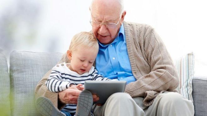 Старый человек смотрит на Ipad с молодым человеком