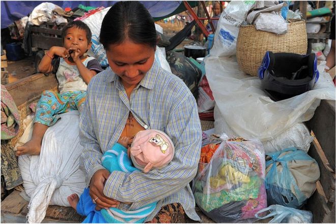 Камбоджийский сельский житель кормит своего ребенка в лагере после того, как 8 февраля 2011 года он бежал из своего дома возле храма Преах-Веар в провинции Преах-Вихеар, примерно в 500 километрах к северо-западу от Пномпеня