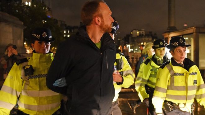 Полиция убирает протестующего против Восстания за вымирание с Трафальгарской площади в центре Лондона