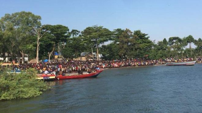 Толпы наблюдают за спасательными работами после того, как лодка перевернулась в Танзании