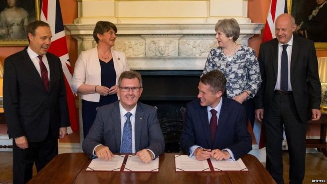 Член парламента от DUP Джеффри Дональдсон и глава Tory Whip Gavin Williamson подписывают соглашение, июнь 2017 года