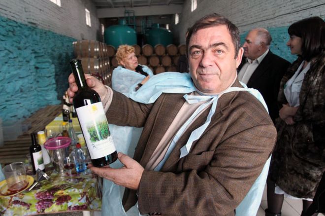 На снимке Владимир Вагнер держит бутылку виноградника "Алтайская лоза" вино