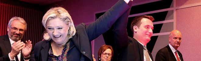 Марин Ле Пен (2-я слева), лидер французской ультраправой Фронтовой национальной партии (ФН), поднимает руку Флориана Филиппо, главного кандидата от ФН на региональных выборах в декабре в регионе Эльзас-Шампань-Арденны-Лотарингии, во время публичного собрания в Хаянге 25 ноября 2015 года.