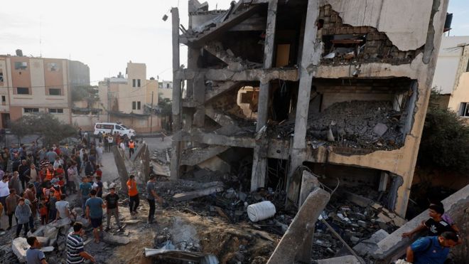 Palestinians search for casualties under the rubble of a building destroyed by Israeli strikes in Khan Younis in southern Gaza