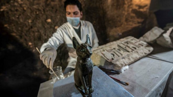 Um arqueÃ³logo egÃ­pcio limpa o bronze antigo egÃ­pcio sentado estÃ¡tua de gato.  10 de novembro de 2018