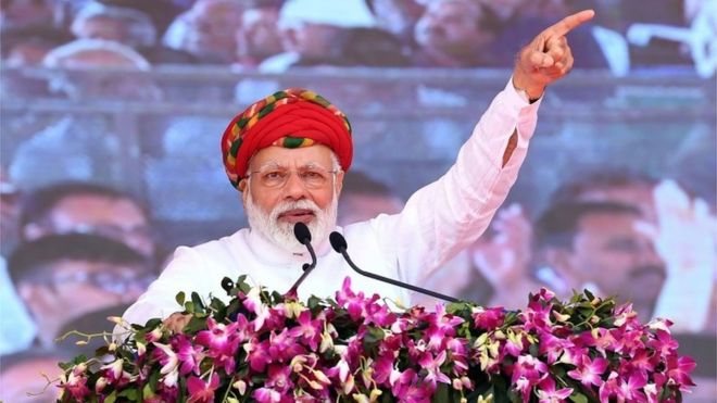 This handout photograph released by India"s Press Information Bureau (PIB) on March 4, 2019, shows Indian Prime Minister Narendra Modi addressing a gathering during during the inauguration of various development projects in Jamnagar, in the Indian state of Gujarat. (Photo by Handout /