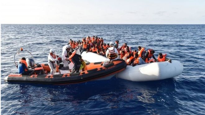 Члены мальтийской неправительственной организации MOAS помогают людям сесть на небольшую спасательную лодку во время спасательной операции мигрантов и беженцев 3 ноября 2016 года у побережья Ливии в Средиземном море.