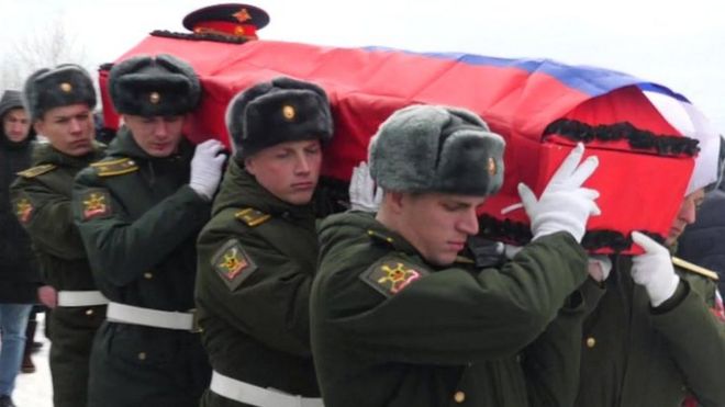 Soldados rusos cargan un ataúd envuelto en la bandera nacional
