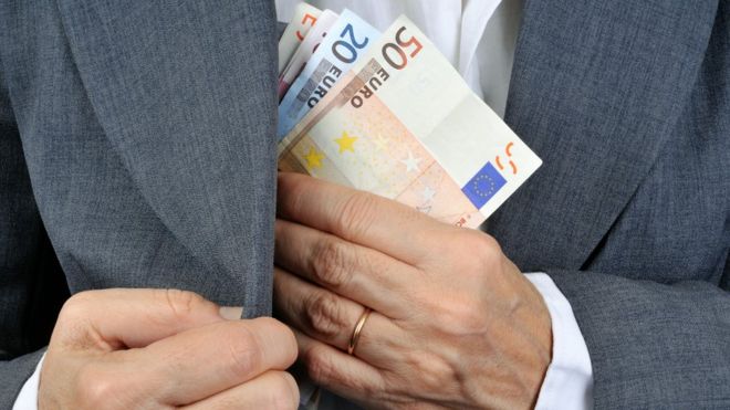 Un hombre guardando euros en un bolsillo