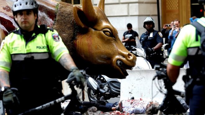Активисты по борьбе с изменением климата окружены полицией, когда они протестуют у Wall Street Bull в Нижнем Манхэттене во время протестов Extinction Rebellion в Нью-Йорке, 7 октября 2019 г.