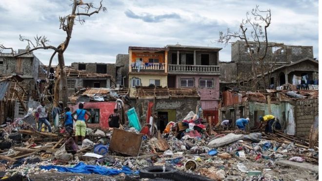 Разрушенные здания и деревья с вещами, разбросанными по земле в городе Джереми, Гаити, 6 октября 2016 года