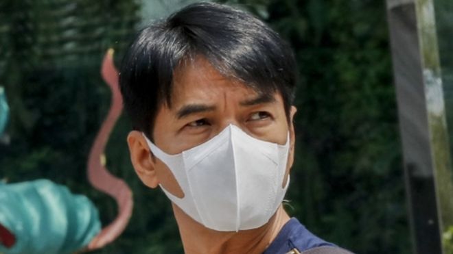 A man wearing a protective mask walks outside a department store in Bangkok, Thailand.