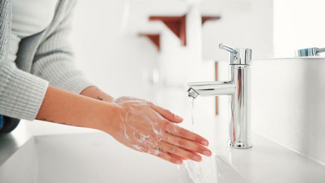 Женщина моет руки