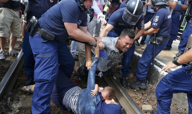 Венгерские полицейские задерживают мигрантов на железнодорожных путях, поскольку они хотят убежать на железнодорожной станции в городе Бичке, Венгрия, 3 сентября 2015 года