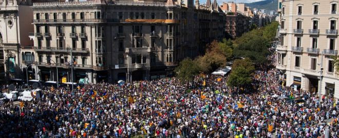 Люди проводят демонстрацию у здания каталонского вице-президента и экономического департамента, когда 20 сентября 2017 года сотрудники полиции проводят поисковую операцию в Барселоне