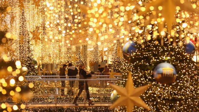 Shoppers walk among Christmas lights in Berlin