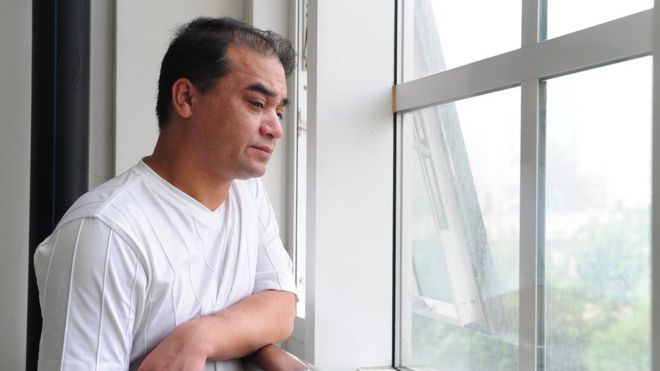 Профессор университета и уйгурский активист Ильхам Тохти делает паузу у окна перед аудиторией в Пекине 12 июня 2010 года