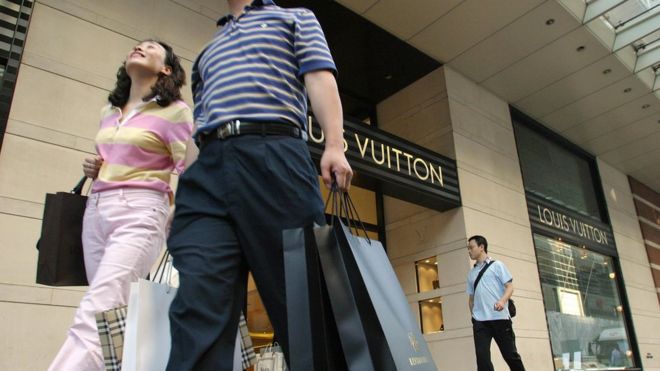 Китайские покупатели проходят мимо магазина Louis Vuitton