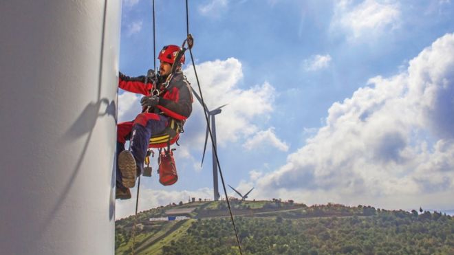 Un técnico trabajando sobre una turbina de viento
