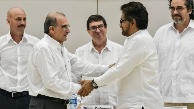 Глава правительственной делегации Колумбии на мирных переговорах Умберто де ла Калле (слева) и глава делегации FARC-EP Иван Маркес (справа) пожимают друг другу руки после подписания соглашения о жертвах конфликта во Дворце конгрессов в Гавана, 15 декабря 2015 года.