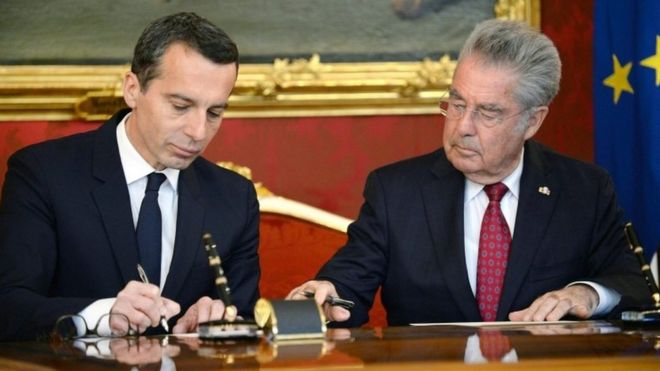 Austria's new chancellor Christian Kern signs the swearing-in documents as chancellor next to outgoing President Heinz Fischer