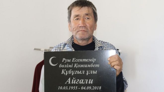 Эсенгали Супыгалиев держит надгробие своего брата Айгали, Казахстан, 2018 год